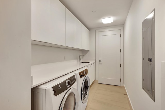 laundry room featuring electric panel, independent washer and dryer, cabinet space, and a sink