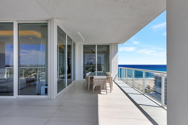 balcony with a water view and a view of the beach