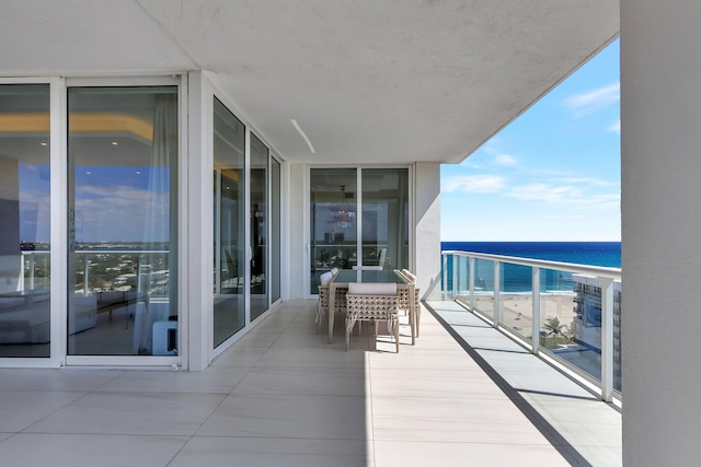 balcony featuring a water view and a beach view