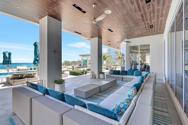 view of patio / terrace featuring ceiling fan, an outdoor hangout area, and a water view