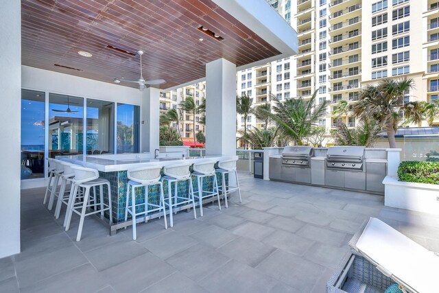 view of patio with grilling area, exterior kitchen, exterior bar, and ceiling fan