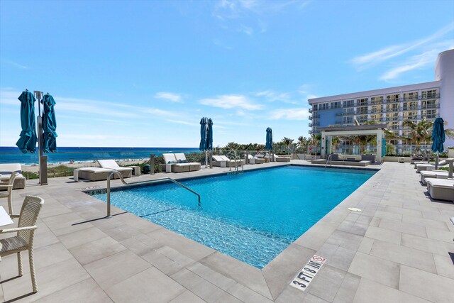 view of swimming pool with a patio and a water view