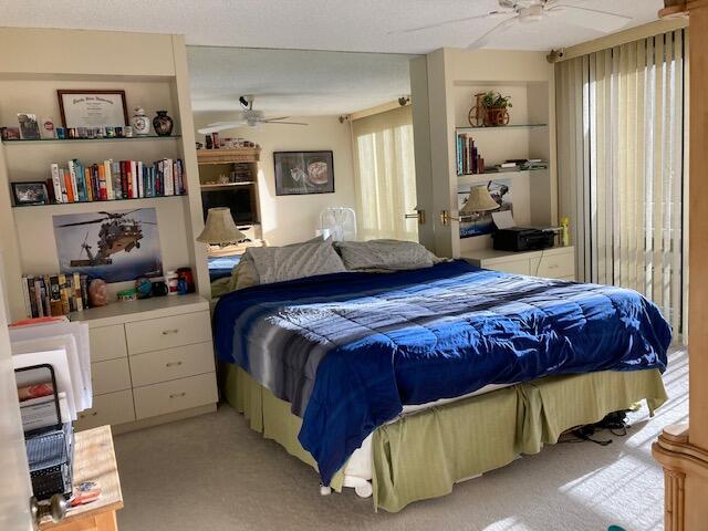 bedroom with light carpet and a ceiling fan