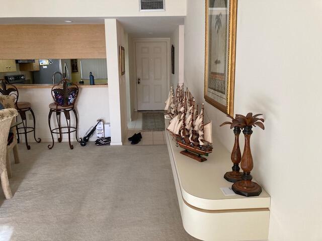 corridor featuring light colored carpet and visible vents
