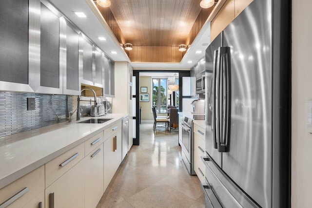 kitchen with wooden ceiling, appliances with stainless steel finishes, a tray ceiling, sink, and white cabinetry