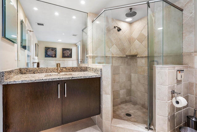 bathroom with vanity, tile walls, and an enclosed shower