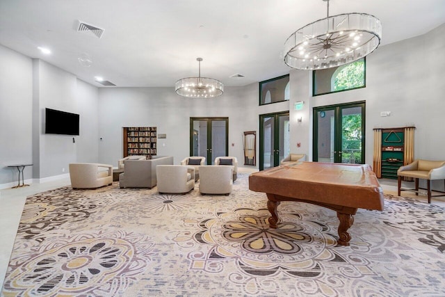 playroom with a towering ceiling, pool table, a chandelier, and french doors