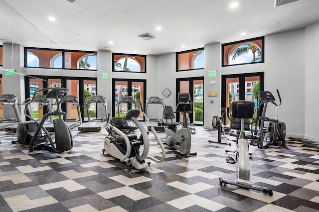 exercise room with a high ceiling and french doors