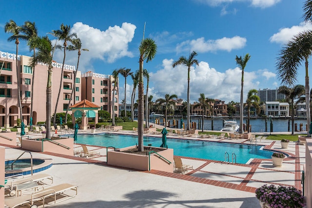 view of swimming pool with a water view and a patio area