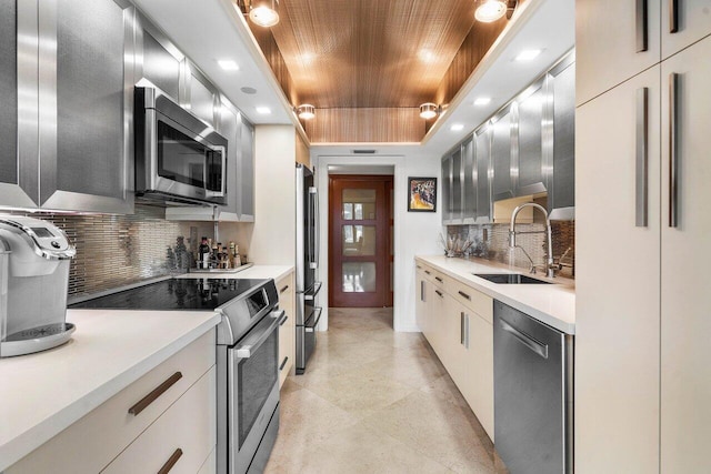 kitchen featuring appliances with stainless steel finishes, wood ceiling, decorative backsplash, and sink