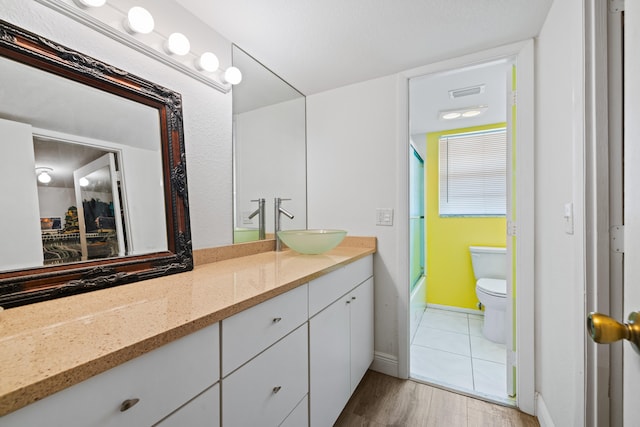 full bathroom with wood-type flooring, shower / bathtub combination, vanity, and toilet