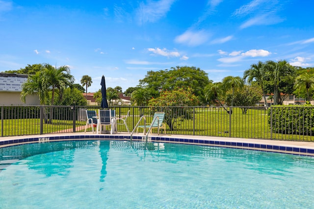 view of swimming pool featuring a lawn