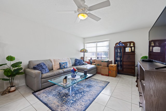 living room with ceiling fan, light tile patterned floors, and a textured ceiling