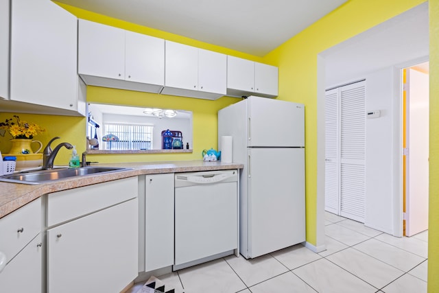 kitchen featuring white cabinets, white appliances, light tile patterned floors, and sink