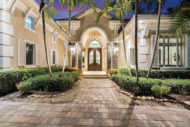 exterior entry at dusk featuring french doors