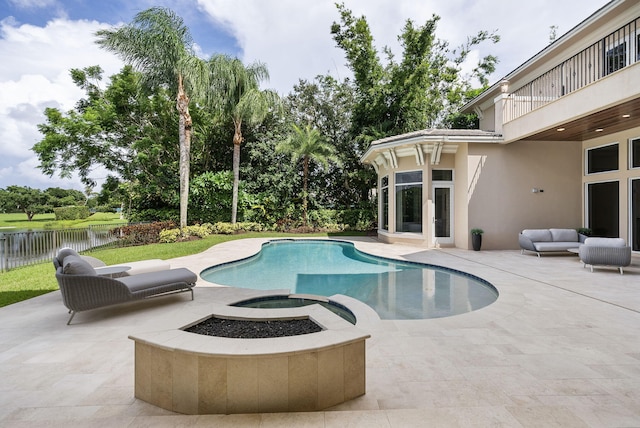 view of pool featuring a water view, an outdoor living space with a fire pit, and a patio