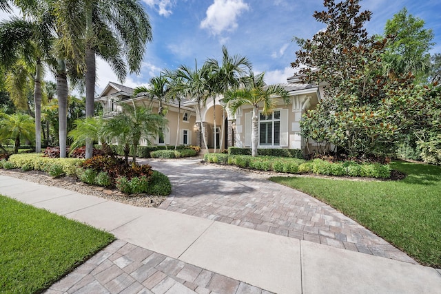 mediterranean / spanish house with a balcony and a front lawn