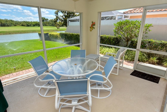 sunroom featuring a water view