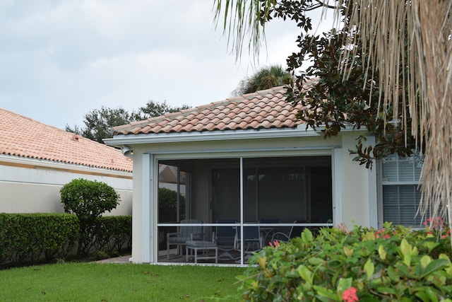 exterior space with a lawn and a sunroom