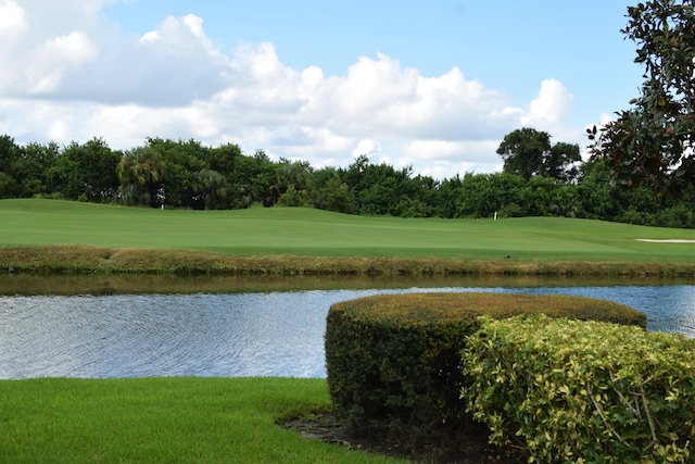 view of property's community featuring a lawn and a water view