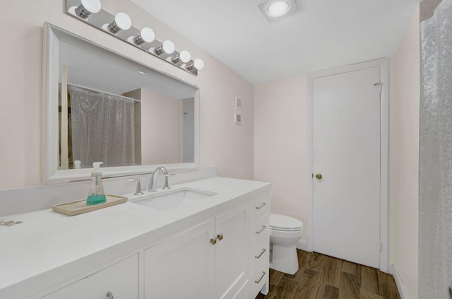 bathroom featuring vanity, toilet, and hardwood / wood-style floors