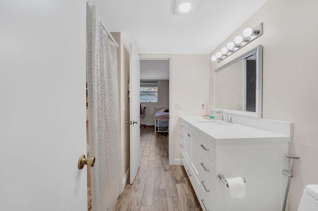 bathroom with vanity, toilet, and wood-type flooring