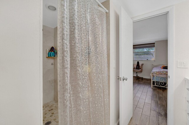 bathroom featuring curtained shower and hardwood / wood-style flooring