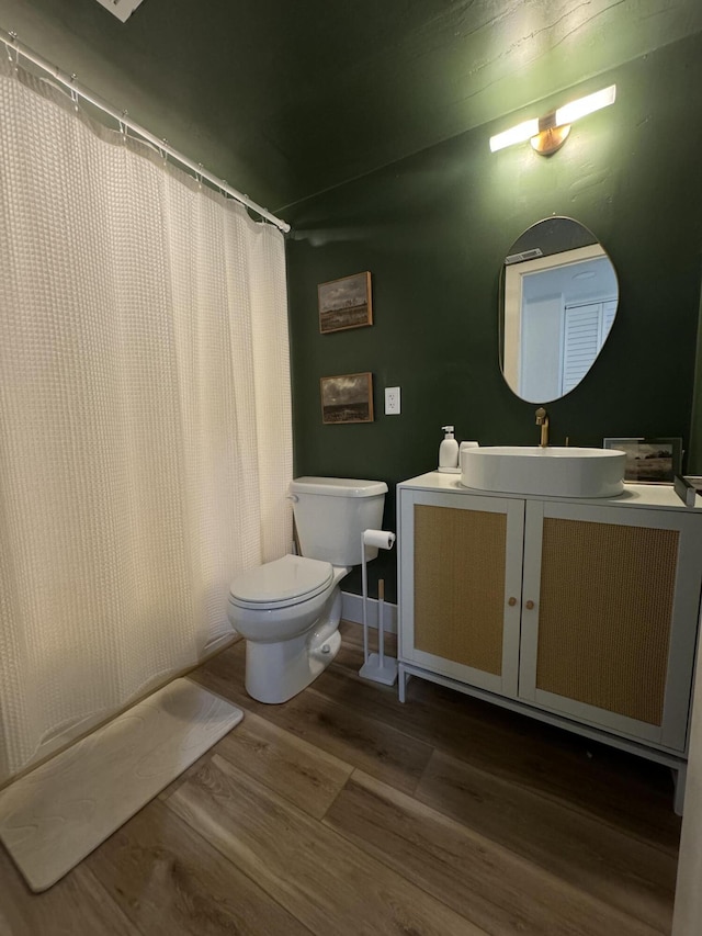 bathroom featuring a shower with shower curtain, vanity, toilet, and wood-type flooring