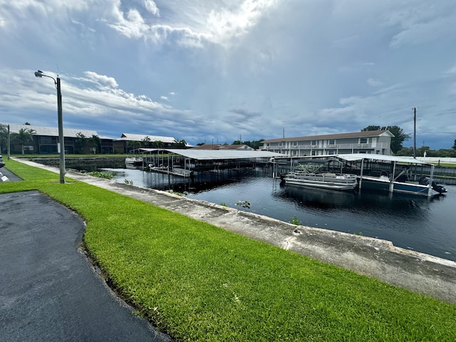 dock area with a lawn and a water view