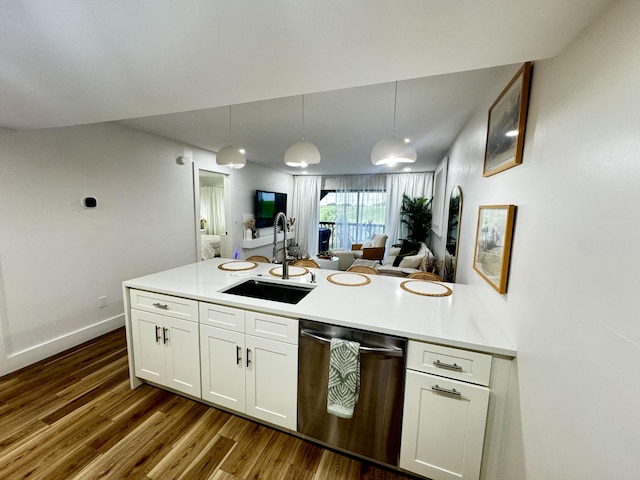 kitchen featuring white cabinets, hanging light fixtures, sink, dark wood-type flooring, and stainless steel dishwasher