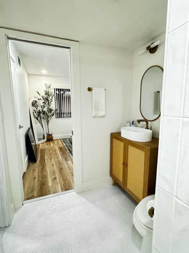 bathroom with vanity, toilet, and hardwood / wood-style floors