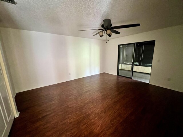 spare room with ceiling fan, dark hardwood / wood-style flooring, and a textured ceiling