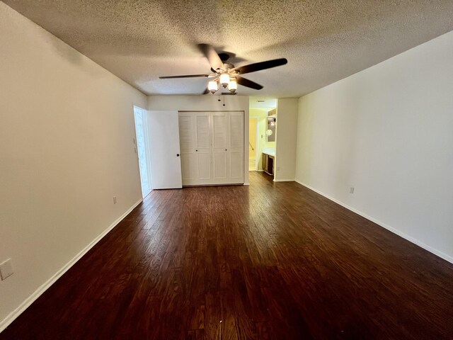 unfurnished bedroom with a closet, a textured ceiling, ceiling fan, and dark hardwood / wood-style floors