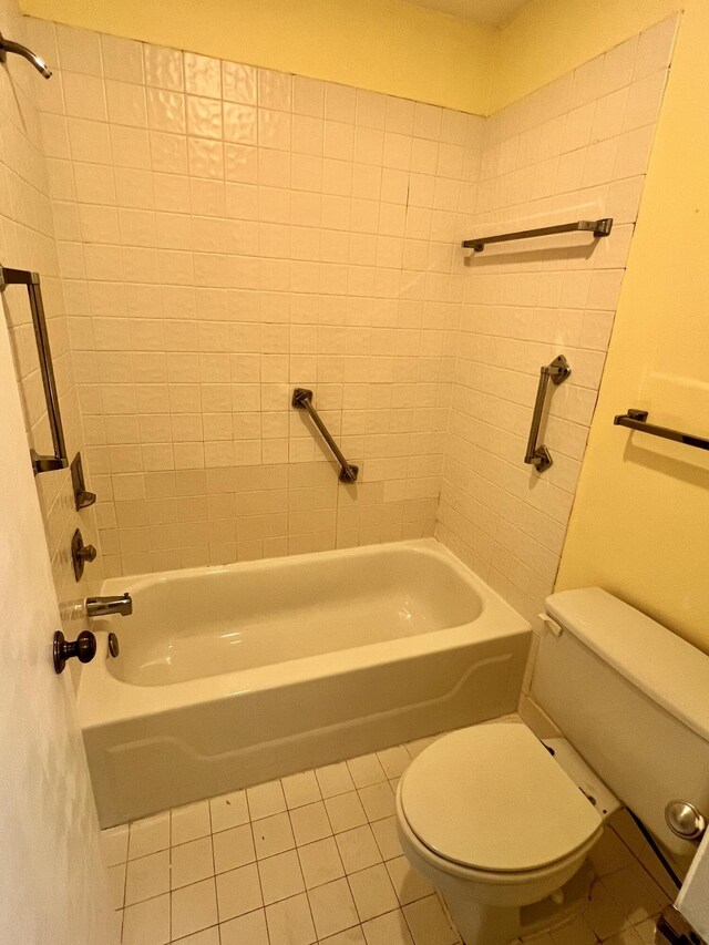 bathroom with tiled shower / bath, toilet, and tile patterned floors