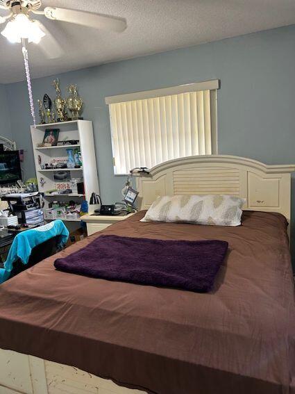 bedroom featuring a textured ceiling and ceiling fan