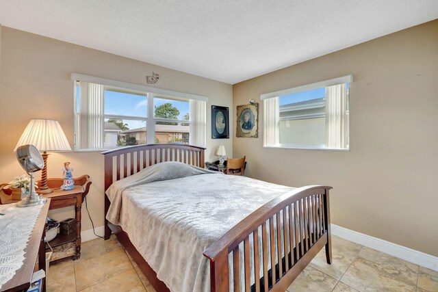 bedroom with a textured ceiling and light tile patterned floors