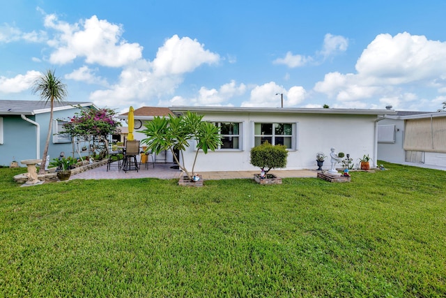 back of house with a lawn and a patio area