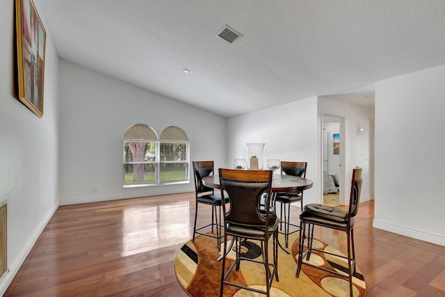 dining area featuring a textured ceiling and hardwood / wood-style flooring