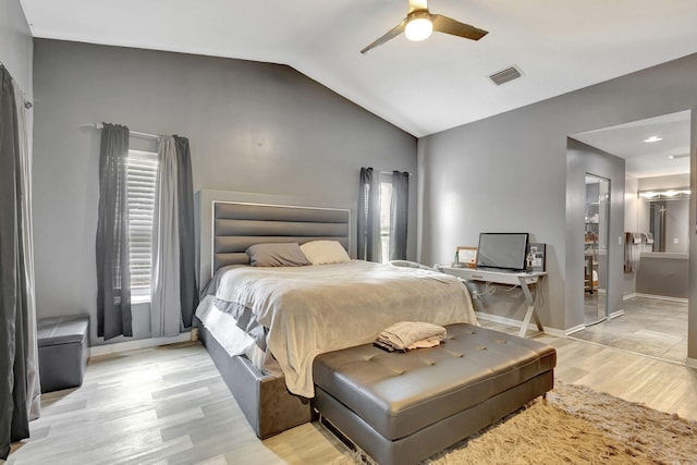 bedroom with vaulted ceiling, light hardwood / wood-style floors, a closet, ceiling fan, and connected bathroom