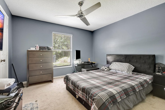 bedroom with a textured ceiling, ceiling fan, and light carpet