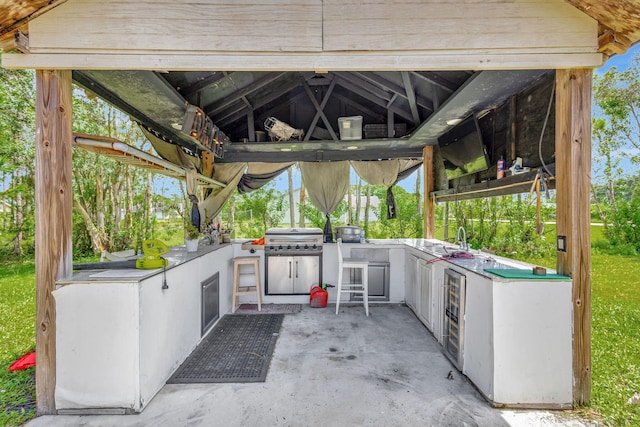 view of patio featuring grilling area, an outdoor kitchen, sink, and a gazebo