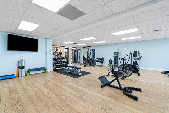 gym featuring hardwood / wood-style flooring and a drop ceiling