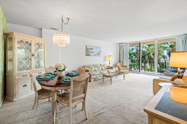 dining space featuring a textured ceiling, light colored carpet, a notable chandelier, and a wall of windows