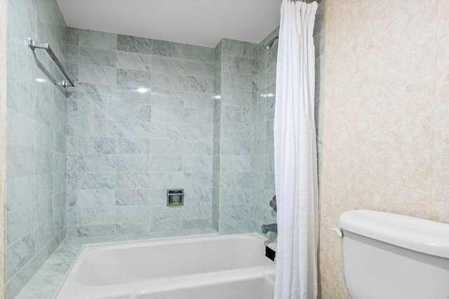 bathroom featuring shower / bath combination with curtain and toilet