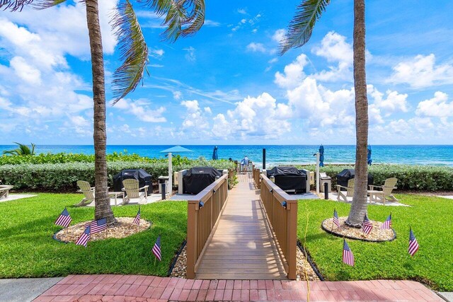 view of property's community with an outdoor hangout area, a yard, and a water view