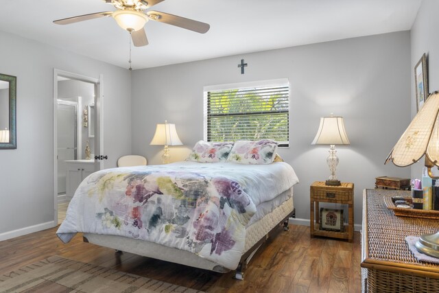 bedroom with dark hardwood / wood-style floors, ceiling fan, and ensuite bath