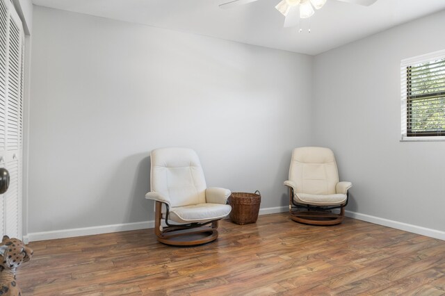 living area featuring wood-type flooring and ceiling fan