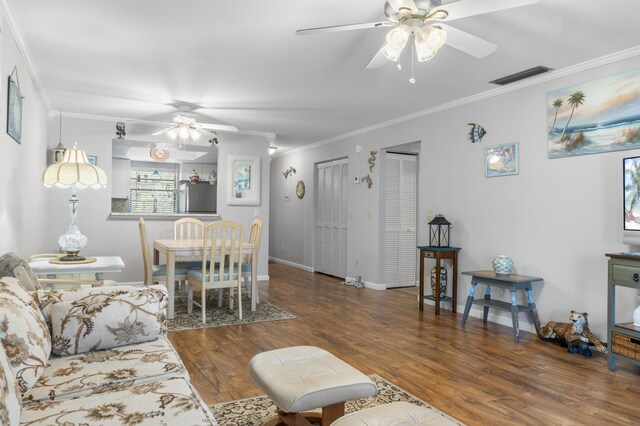 living room featuring ceiling fan, hardwood / wood-style flooring, crown molding, and a healthy amount of sunlight