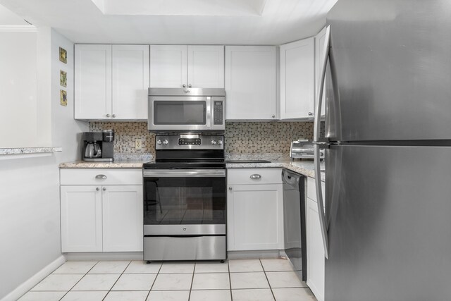 kitchen with decorative backsplash, light tile patterned floors, stainless steel appliances, and white cabinets