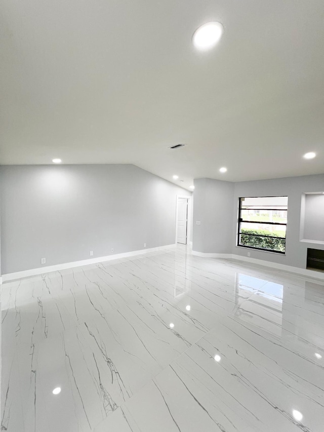 spare room featuring lofted ceiling